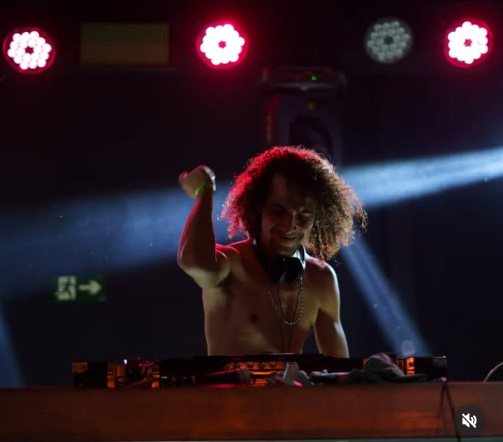 Djias em apresentação com feixe de luz no palco